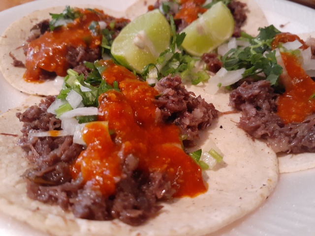 Tacos de barbacoa de res con salsa roja y limón